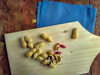 Peanuts on wooden cutting board, still life in vintage style