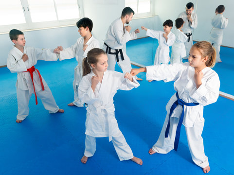 Happy kids sparring in pairs in karate class
