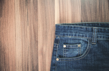 Blue jeans on wooden background.