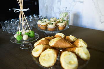 delicious cupcakes with cream and pastries on buffet table
