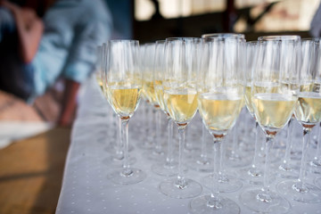 Many transparent glasses with champagne are on the table