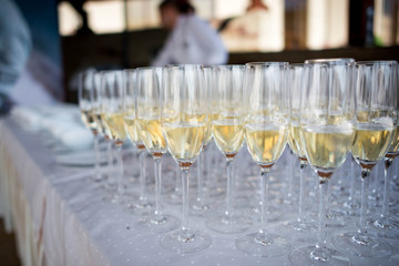 Many transparent glasses with champagne are on the table