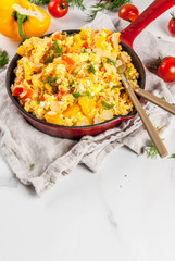 Mexican food recipes, Revoltillo de Huevos, Scrambled Eggs a la Dominicana, in portioned skillet, on white marble table,copy space