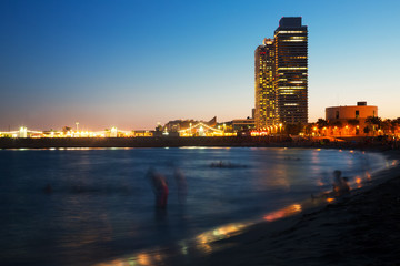 Fototapeta premium Barceloneta beach with skyscrapers in sunset