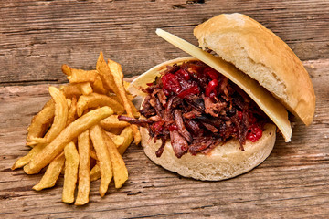 Barbeque Pulled lamb Sandwich with cheese,jam of hot pepper,Sauce and Fries on wooden background,Fast food