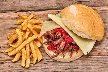 Barbeque Pulled lamb Sandwich with cheese,jam of hot pepper,Sauce and Fries on wooden background,Fast food