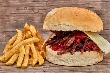Barbeque Pulled lamb Sandwich with cheese,jam of hot pepper,Sauce and Fries on wooden background,Fast food