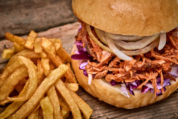 Barbeque Pulled pork Sandwich with BBQ Sauce,salad with red cabbageonion,Sauce and Fries on wooden background,Fast food