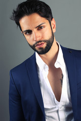 Jeune homme stylé portant une belle barbe en studio.