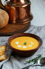 pumpkin cream soup, vintage style, old ceramic boul, rosmarin
