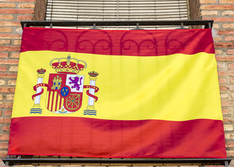 a Spanish flag on a balcony of a private house
