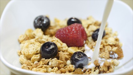  Berries, flakes, pour milk. Raspberry with milk. Raspberry in milk. Berries and flakes are filled with milk.