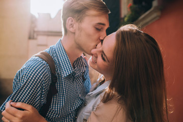 young and beautiful guy and girl kiss each other on the street