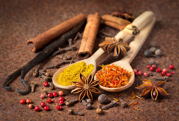 Vanilla, cinnamon and other spices on a rusty table.