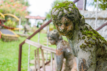 escultura abandonada en jardin con mirada triste