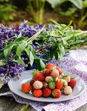 Pineberry and strawberry on the wooden old background