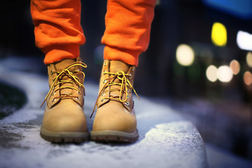 Young woman in winter shoes on street at night