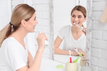Young woman brushing her teeth in bathroom