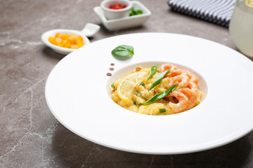 Plate with tasty shrimps and grits on table