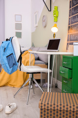 Modern child room interior with desk and laptop