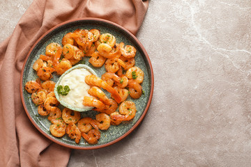 Plate with fried shrimps and sauce on grey background, top view