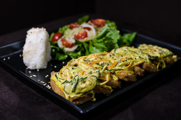 Japanese pan fry with salad and rice in black background.