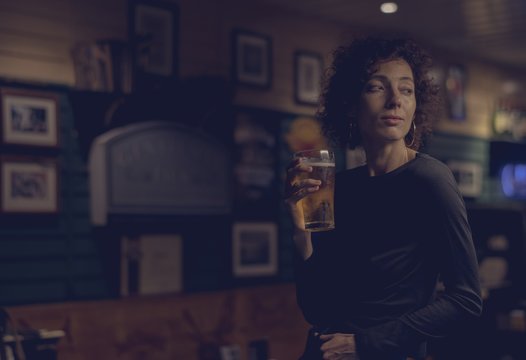 Woman Having A Beer At A Bar