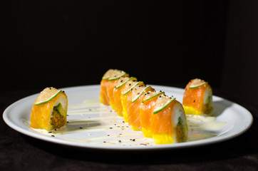 Sushi rolls in white plate and dark background