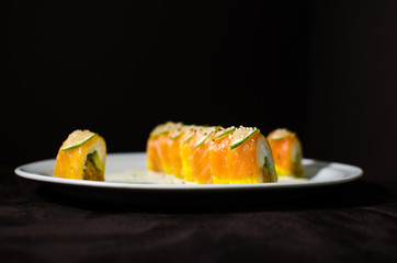 Sushi rolls in white plate and dark background