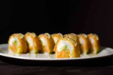 Sushi rolls in white plate and dark background