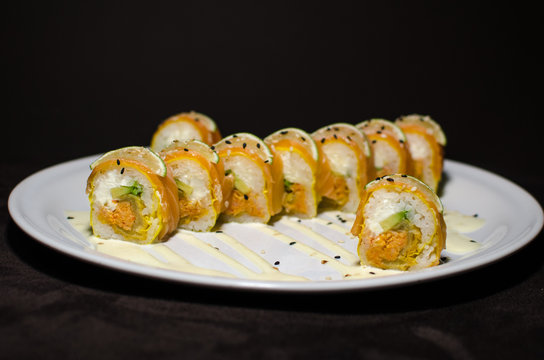 Sushi rolls in white plate and dark background