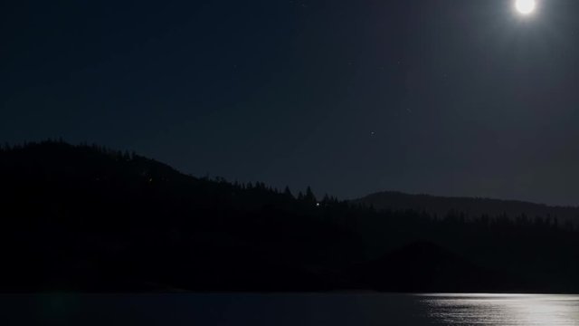 Time Lapse Of The Full Moon Rising Over A Forested Hillside And Lake