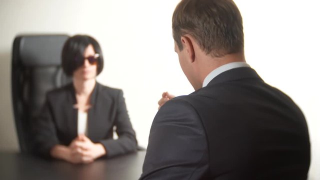 a brunette woman in a suit asks questions to a man in an interview. 4k. interview. recruitment