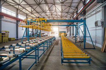 Insulation sandwich panel production line. Machine tools, roller conveyor in workshop
