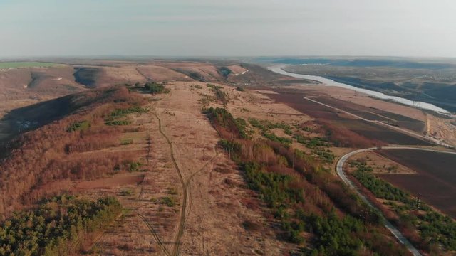 Aerial View from drone. Flying over autumn slope with trees and river. Beautiful green mountain ridges. Flying over high trail, revealing spectacular valleys with fir.