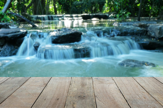 Old wooden foreground with blurred Waterfall background, copy space © damrong