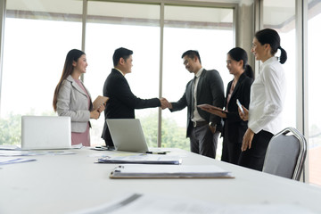 Business people shaking hands, finishing up a meeting in the office.