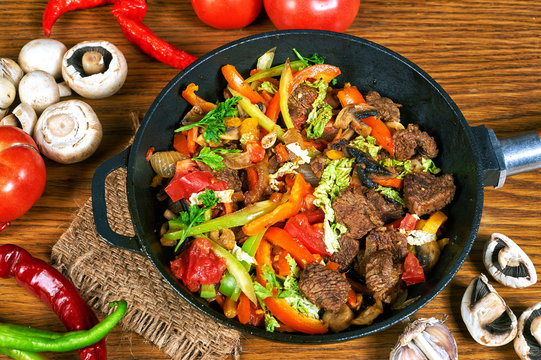 fried meat with vegetables in a pan
