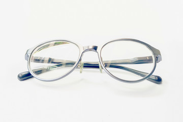 Closeup on Eyeglasses object with bright light on white paper background.
