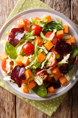 healthy food: vegetarian salad of sweet potato with fresh vegetables close-up on a table. Vertical top view