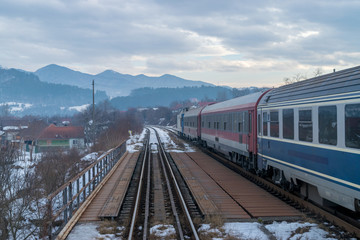 View to some railway paths, a train and the mountains in Transiylvania