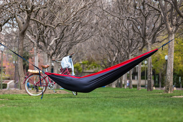 Student on college campus park lawn resting and relaxing between classes in hammock 