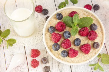 Oatmeal with raspberries.Healthy food for breakfast.Tasty oatmeal with berries in bowl on table