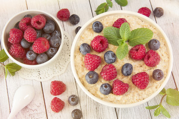 Oatmeal with raspberries.Healthy food for breakfast.Tasty oatmeal with berries in bowl on table