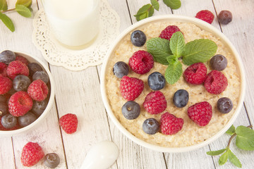 Oatmeal with raspberries.Healthy food for breakfast.Tasty oatmeal with berries in bowl on table