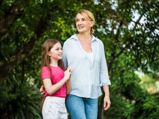 Obraz premium Mother and daughter relaxing walking in a park. Family and lifestyle concept