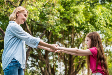 Mother and daughter having fun together in a park. Family and lifestyle concept