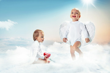 Conceptual portrait of a two cute cupids on the cloud