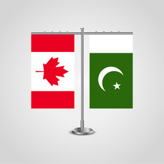 Table stand with flags of Canada and Pakistan.Two flag. Flag pole. Symbolizing the cooperation between the two countries. Table flags