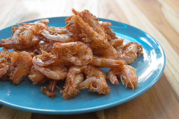 Deep fried crispy shrimp on blue ceramic plate on wood table